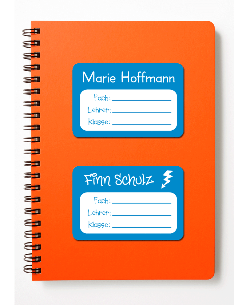 Orangefarbener Collegeblock auf weißem Hintergrund. Auf dem Schulheft kleben zwei mittelblaue Schulbuchaufkleber. Der obere Schulbuchaufkleber ist mit dem Namen von Marie Hoffmann in der Schriftart Clear & Simple beschriftet. Der untere Aufkleber ist mit den beiden Namen Finn Schulz und zusätzlich noch dem Motiv eines Blitzes bedruckt. Man kann auf beiden Schulbuchaufkleber das Fach, den Lehrer und die Klasse mit einem Stift eintragen.
